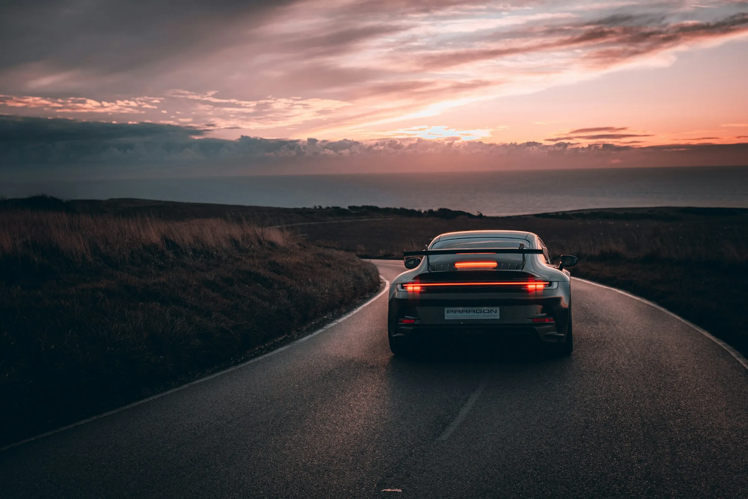 Porsche 911 GT3 op een verlaten weg bij schemering